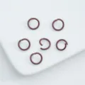 Close-up of reddish-brown painted alloy open jump rings for DIY jewelry making. - 6mm (100pcs) / Dark Red