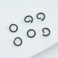 Detailed macro view of black painted alloy open jump rings for DIY jewelry making - 6mm (100pcs) / Black