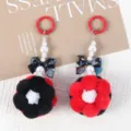 Macro view of handmade beaded flower pom-pom charms with pearl and bow details - 1 Piece / Black + Red