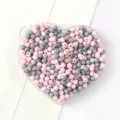 Gros plan de perles rondes en acrylique roses et grises pour bijoux DIY dans un plateau cœur - 05 Couleurs Mixtes