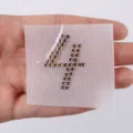 Primer plano detalle del parche termoadhesivo de estrás número 4, piedras marrones para ropa. - Número 4