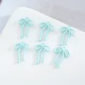 Primo piano di ciondoli a fiocco in lega azzurra, ideali per creazione di gioielli fai-da-te. - 10 Pezzi/Confezione / Azzurro