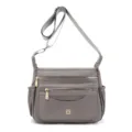 Detailed view of a grey multi-compartment nylon crossbody bag for women's daily travel. - Gray