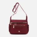 Detail of wine red multi-compartment nylon crossbody bag with gold zippers. - Purple