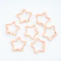 Close-up of peach painted star-shaped spring clasps for DIY jewelry making and keychains. - Flesh Pink