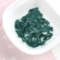 Detailed view of 2x7mm dark green silver-lined glass bugle beads for DIY jewelry - 20g/Pack / Dark Green