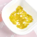 Close-up of 2x7mm golden glass bugle beads for DIY jewelry making in a white bowl - 20g/Pack / 18# Yellow