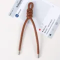 Detailansicht eines braunen Leder geflochtenen Knoten Schlüsselanhänger und Taschenanhängers. - Braun