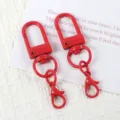 Detail view of colorful metal U-shaped swivel snap hooks and lobster clasps for DIY crafts. - Red