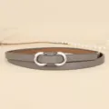 Detailed close-up of a minimalist grey thin leather belt with a silver infinity buckle - 110cm / Light Gray