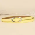 Close-up of a minimalist macaron yellow thin belt with a silver figure-8 buckle. - 110cm / Lemon Yellow