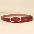 Detailed view of a slim red leather belt featuring a polished silver figure-eight buckle - 110cm / Burgundy
