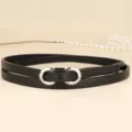 Detail of a slim black leather belt featuring a silver figure-eight metal buckle - 110cm / Black