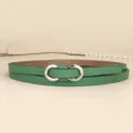 Detail of slim green leather belt with a silver infinity-shaped metal buckle - 110cm / Grass Green