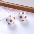 Dettaglio macro di ciondoli a forma di pallone da calcio 3D in resina per gioielli fai da te - Marrone chiaro