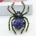 Exquisites Detail einer Vintage-Spinne-Brosche mit funkelnden grünen und blauen Steinen. - Blau