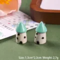 Detailed macro view of two miniature green-roofed resin houses for landscape decor - Mushroom House