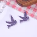Vista detallada de parches de pájaros golondrina de resina púrpura para joyas DIY y accesorios - Púrpura