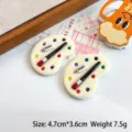 Close-up of miniature palette resin charms with tiny paint tubes and brushes - Off White