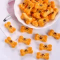 Detailed macro shot of cute resin bone biscuit charms for DIY jewelry and accessories - Dark Yellow + Coffee Paw Print