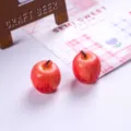 Close-up of two realistic 3D resin miniature apple charms for DIY dollhouse crafts - Red Apple