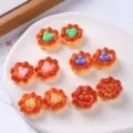 Macro detail view of colorful miniature resin fruit tarts on a white textured plate - Mixed