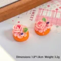 Détail de deux gâteaux miniatures en résine avec glaçage rose pour décor de maison de poupée - Gâteau au Miel et à la Rose