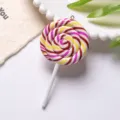 Detailed close-up showing the vibrant spiral patterns on a polymer clay lollipop charm - With Eye Pin Hook / Orange Red