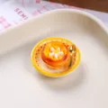 Detailed macro view of a miniature resin egg tart fridge magnet with a gold spoon. - Flower Egg Tart Plate
