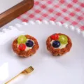Close-up of realistic miniature fruit tarts with strawberry, kiwi, and blueberry toppings. - Kiwi Strawberry Tart