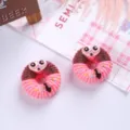 Detailed view of miniature pink and brown cartoon animal donut resin charms for DIY crafts - Three-Eyed Irregular Style
