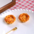 Detailed view of two realistic resin egg tart models on a white plate with a fork. - Original Egg Tart