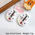 Detailed macro shot of miniature resin paint palette charms with brush and paint tube - White