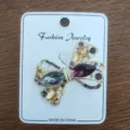 Close-up of elegant bow brooch featuring multicolored rhinestones on a gold-tone alloy base - Bowknot Style (6)
