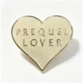 Macro detail of a vintage heart-shaped glitter enamel pin with PREQUEL LOVER gold lettering - 爱心闪粉胸针