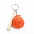 Detailweergave van creatieve honkbalsleutelhanger met oranje handschoen en knuppel - Oranje