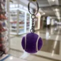 Primer plano de un llavero con forma de pelota de tenis morada y aro plateado. - Estilo Tenis / 3.2cm / Púrpura