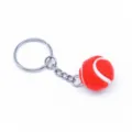 Close-up van een mini rode tennisbal sleutelhanger met realistische harige textuur. - 2cm / Rood