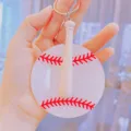 Close-up of acrylic baseball keychain with a mini wooden bat charm held in hand - Keychain / 6cm Diameter
