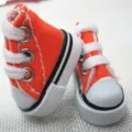 Detailed macro view of mini 3.5cm orange canvas doll shoes featuring white laces - Orange