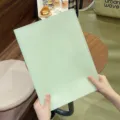 Handgehaltene Detailansicht einer mintgrünen A3-Testpapier-Organizer-Mappe im Lifestyle - Grün