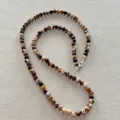Detailopname van een lange ketting van natuurlijke zebra-jaspis kralen met slot - Bruin