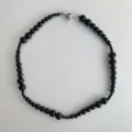 Elegant black bead necklace featuring graduated spheres and a secure magnetic clasp. - Size Gradient / Black