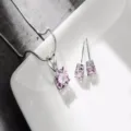 Primo piano dettagliato di elegante set collana e orecchini con pietra rosa metallo argento. - Strass Rosa