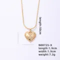 Close-up of gold snake chain necklace featuring a crystal paved letter X heart pendant. - Letter X