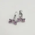 Dettaglio in primo piano di orecchini a cerchio in argento con zircone rosa a cuore. - Bianco Oro Rosa
