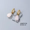 Detail shot of elegant gold-plated drop earrings with pink gemstone pendants, chic and stylish. - Pink