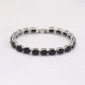 Eleganter silberfarbener Tennisarmband mit ovalen schwarzen Zirkonsteinen und Klappverschluss - 19cm / Silber Schwarzer Strass