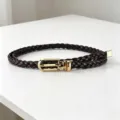 Detailed close-up view of the dark brown braided belt featuring an elegant gold metal buckle. - Coffee