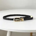 Black braided thin belt with gold metal buckle, detail view of womens dress waist accessory. - Black